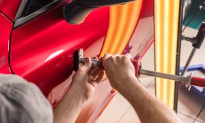 The technician removes dents on the car using the method without painting. PDR. Car body repair. High quality photo